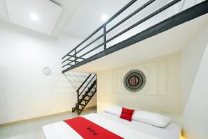 a bedroom with a bed and a staircase at JM Guest House Lamaran RedPartner in Karawang