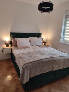 a large bed with a green headboard in a bedroom at Green Diamond in Vrnjci