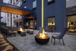 a patio with a fire pit in front of a building at Home2 Suites By Hilton Salisbury Fruitland in Fruitland