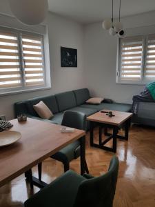 a living room with a couch and tables and windows at Green Diamond in Vrnjci