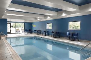a swimming pool with blue walls and chairs around it at Home2 Suites By Hilton Salisbury Fruitland in Fruitland