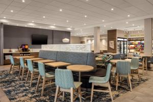a restaurant with tables and chairs and a tv at Home2 Suites By Hilton Salisbury Fruitland in Fruitland