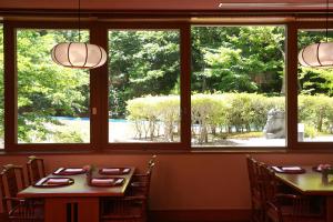 a dining room with windows looking out onto a garden at Hilton Takayama Resort in Takayama
