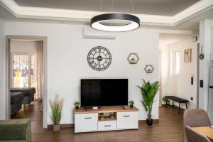 a living room with a flat screen tv on a white wall at Lumino Suites Corfu in Corfu