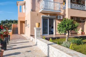 a house with a walkway in front of it at Lumino Suites Corfu in Corfu