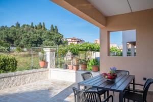 a patio with a wooden table and chairs on a balcony at Lumino Suites Corfu in Corfu