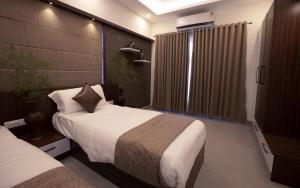 a hotel room with two beds and a window at Feliz Homes Kottakkal in Kottakkal +36 photos
