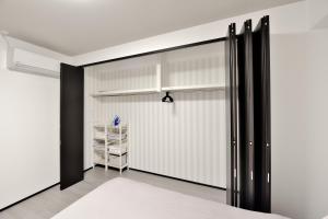a bedroom with white walls and black sliding doors at Room 701 Large 3LDK 98sqm Near Namba Big Balcony Ideal for Groups and Long Stay in Osaka