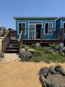 a blue house with a deck with rocks in front of it at Campo Rivera Beach Community in La Misión