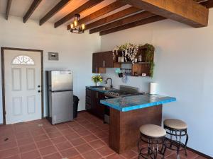 a kitchen with a refrigerator and a counter with stools at Campo Rivera Beach Community in La Misión
