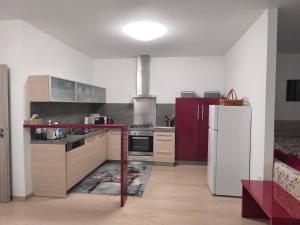 a kitchen with a white refrigerator and a red table at Apartmán Kurdějov in Hustopeče