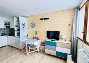 a kitchen with a table and a television in a room at Appartement praloup 1600 in Pra-Loup