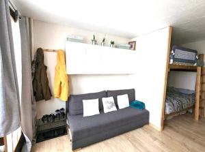 a couch sitting in a room with a bed at Appartement praloup 1600 in Pra-Loup