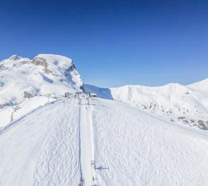 a snow covered mountain with skiers on a ski slope at Appartement praloup 1600 in Pra-Loup