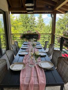 a long table with chairs and a pink table cloth at Cabana Orcas in Harghita-Băi