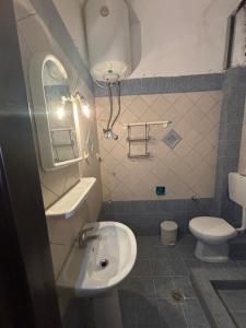 a small bathroom with a sink and a toilet at Val beach apartment in Nea Potidaea