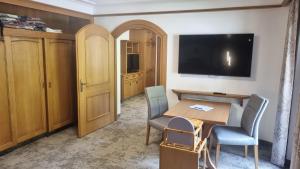 a room with a table and chairs and a television at Adlerhorst , Gstan 31 in Finkenberg
