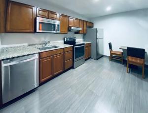 a kitchen with wooden cabinets and stainless steel appliances at Rodeway Inn Old Town Scottsdale in Scottsdale