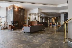 a lobby with a couch and chairs and a fireplace at Quality Inn Rouyn-Noranda in Rouyn-Noranda