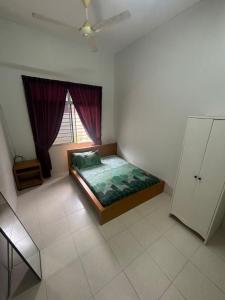 a bedroom with a bed in a room with a window at Damai Ria INAP DESA in Jerantut