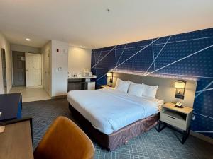 a hotel room with a large bed and a kitchen at Comfort Inn & Suites Sturbridge-Brimfield in Sturbridge +44 photos