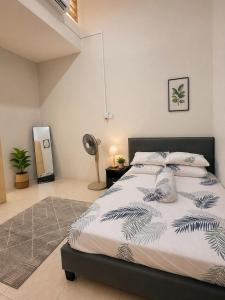a bedroom with a large bed and a fan at Damai Ria INAP DESA in Jerantut