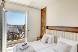 a bedroom with a bed and a large window at Arxontissa Rooms in Ermoupoli