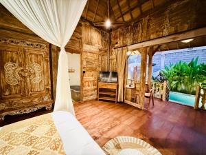 a bedroom with wooden walls and a bed in a room at Sunshine dijoglo villa in Ubud