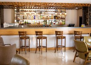 a bar with wooden stools in a restaurant at Grand Palace Hotel Lusaka in Lusaka