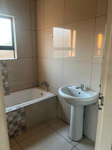a bathroom with a sink and a bath tub at Mafjoint5 in eMalahleni