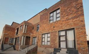 an old brick building with stairs in front of it at Mafjoint5 in eMalahleni