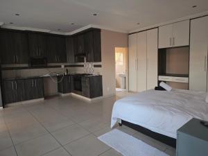a large bedroom with a bed and a kitchen at Mafjoint5 in eMalahleni