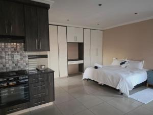 a large bedroom with a bed and a kitchen at Mafjoint5 in eMalahleni