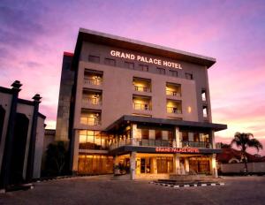 a grand palace hotel with a sunset in the background at Grand Palace Hotel Lusaka in Lusaka