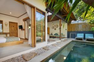 a bedroom and a pool in a villa at Villa Casa Koko in Gili Islands