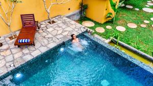a person swimming in a swimming pool at Taro River Resort Negombo in Otarawadiya