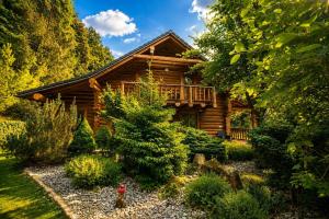 a log cabin surrounded by trees and bushes at Pohádkový Srub Salaš in Salaš