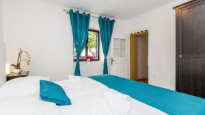 a bedroom with blue curtains and a bed at Vila Iris - Opatija by Villas Guide in Breza +63 photos