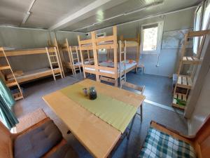 a room with a table and chairs and bunk beds at Camp ŠMICA in Luče
