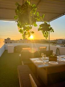 a table with wine glasses on a balcony with the sunset at Skyview Apartment- Rooftop Penthouse with Sunset & Sea Views in Flic-en-Flac