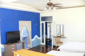 Huxiにあるサンライズ B＆Bの青い壁のベッドルーム(ベッド1台、テレビ付)