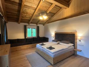 a bedroom with a large bed and a couch at Ferienwohnungen Unterdürmoos Apartments mit Chalet-Charme auf 1050 m , Alleinlage in Annaberg im Lammertal