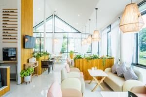 a living room with white furniture and large windows at UR The Private Huahin in Hua Hin