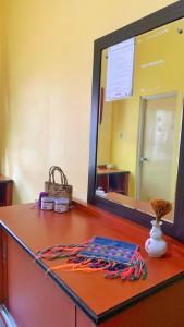 a mirror sitting on top of a wooden counter with a table at D'Oen House Banjarbaru in Banjarbaru +3 photos
