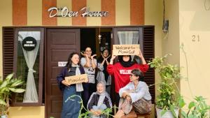 a group of people holding signs in front of a house at D'Oen House Banjarbaru in Banjarbaru