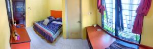 a small room with a bed and a window at D'Oen House Banjarbaru in Banjarbaru