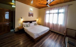 a bedroom with a large bed and a window at Pine Haven Resorts in Takdāh