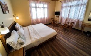 a bedroom with a bed and a table and chairs at Pine Haven Resorts in Takdāh