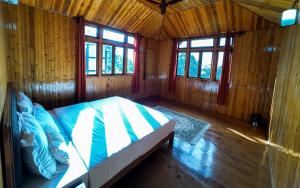 a bedroom with a bed in a wooden room at Pine Haven Resorts in Takdāh