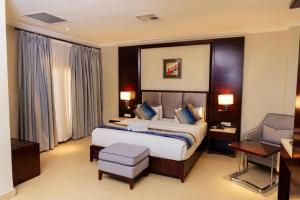 a hotel room with a bed and a chair at Grand Palace Hotel Lusaka in Lusaka +59 photos